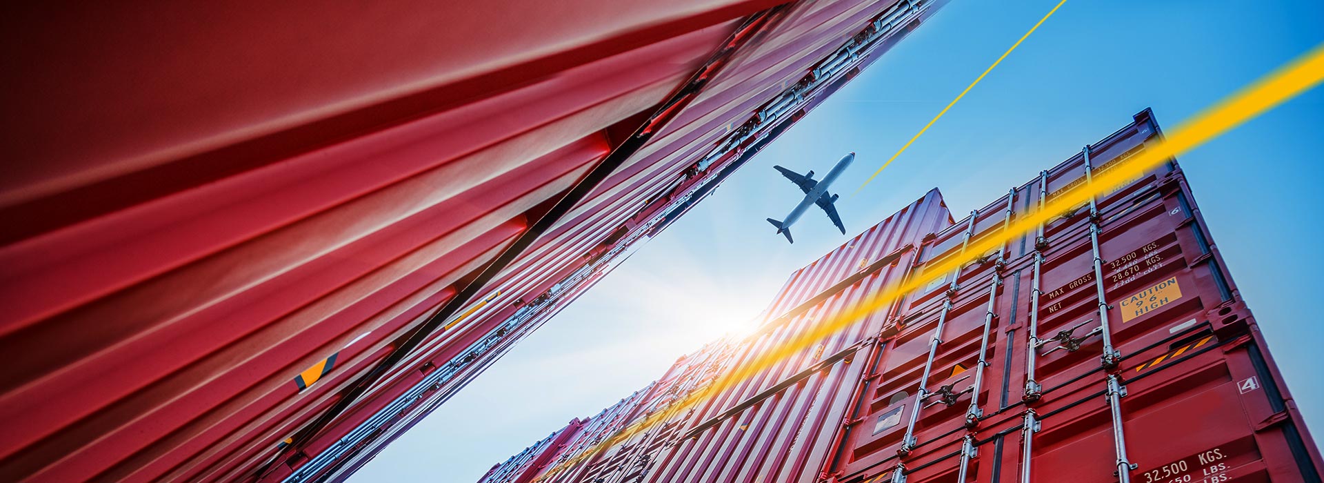 Flugzeug fliegt über Schiffscontainer | LGI